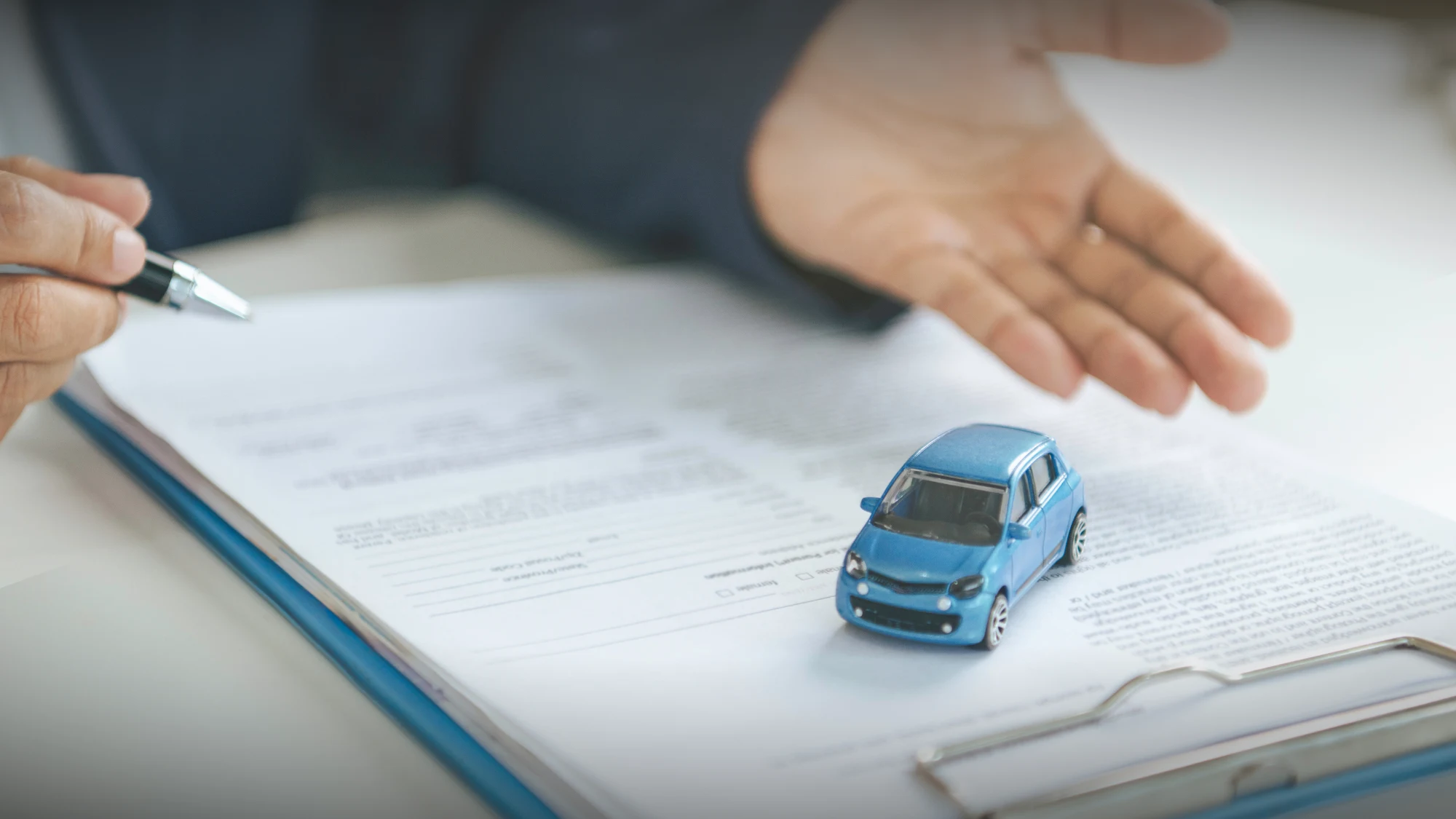 Auto insurance agent reviewing coverage options beyond state minimum requirements with policy documents.